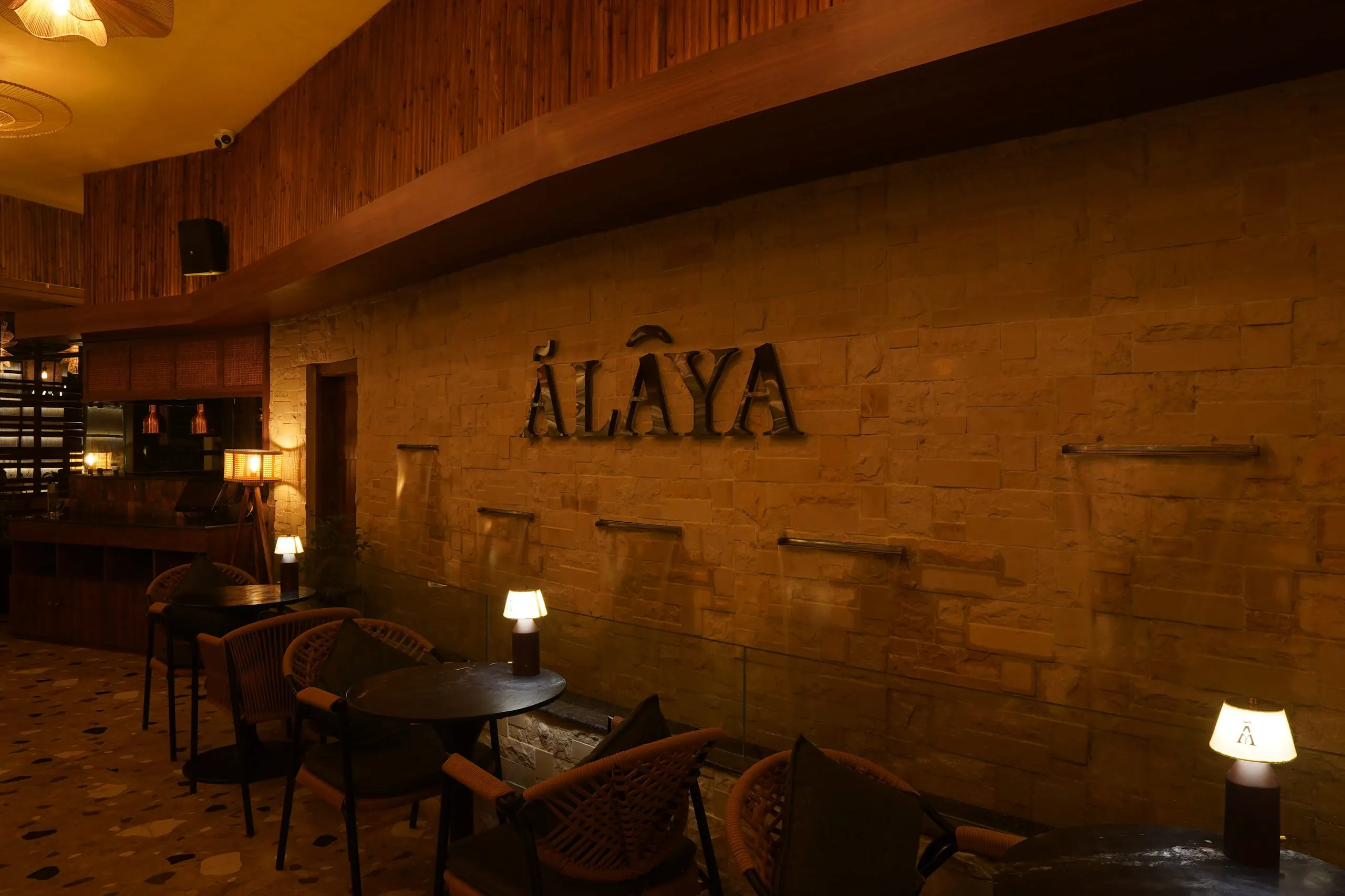The Ālaya name on a lit stone wall above the evening dining room