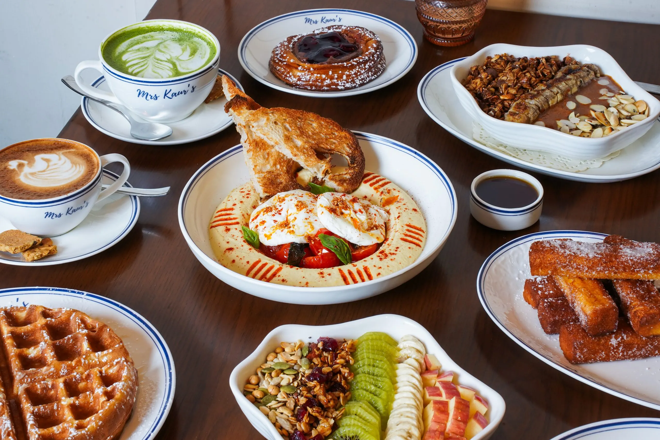 A breakfast spread at Mrs Kaur's: waffles, eggs, bowls and coffee on a timber table