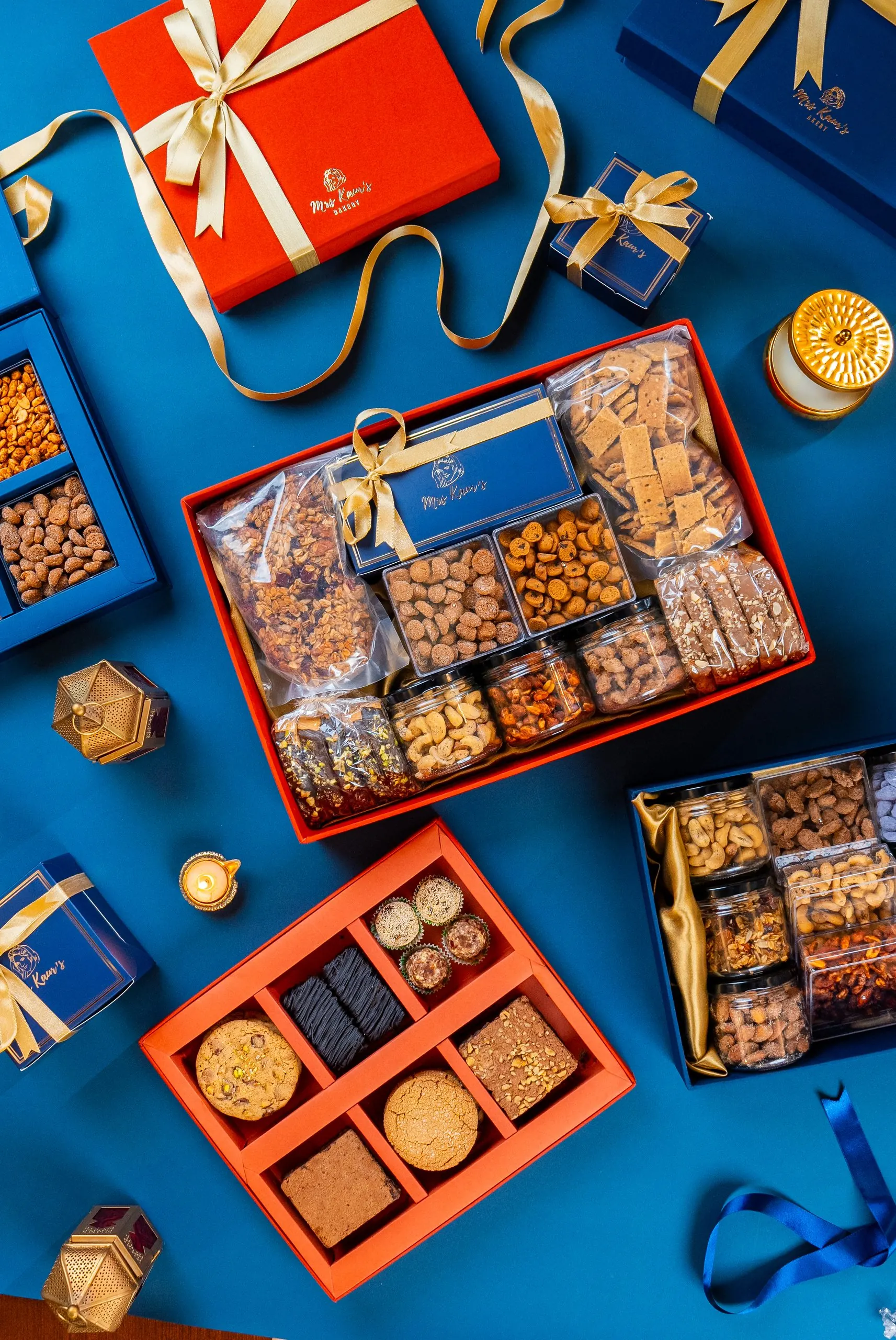 Mrs Kaur's gift boxes of nuts, cookies and brownies, tied with ribbon on a blue ground