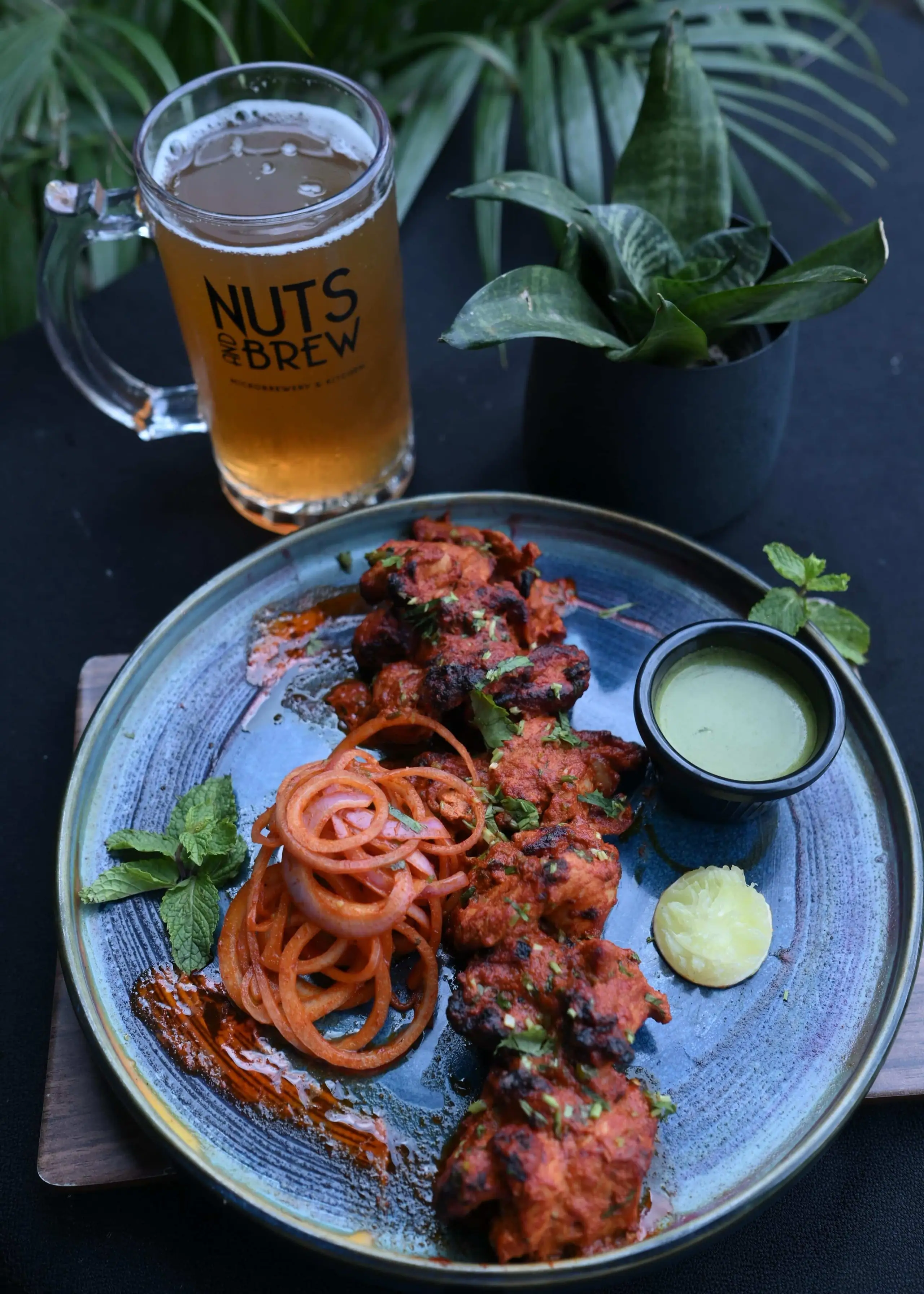 A tikka plate and a house beer in a branded Nuts & Brew mug