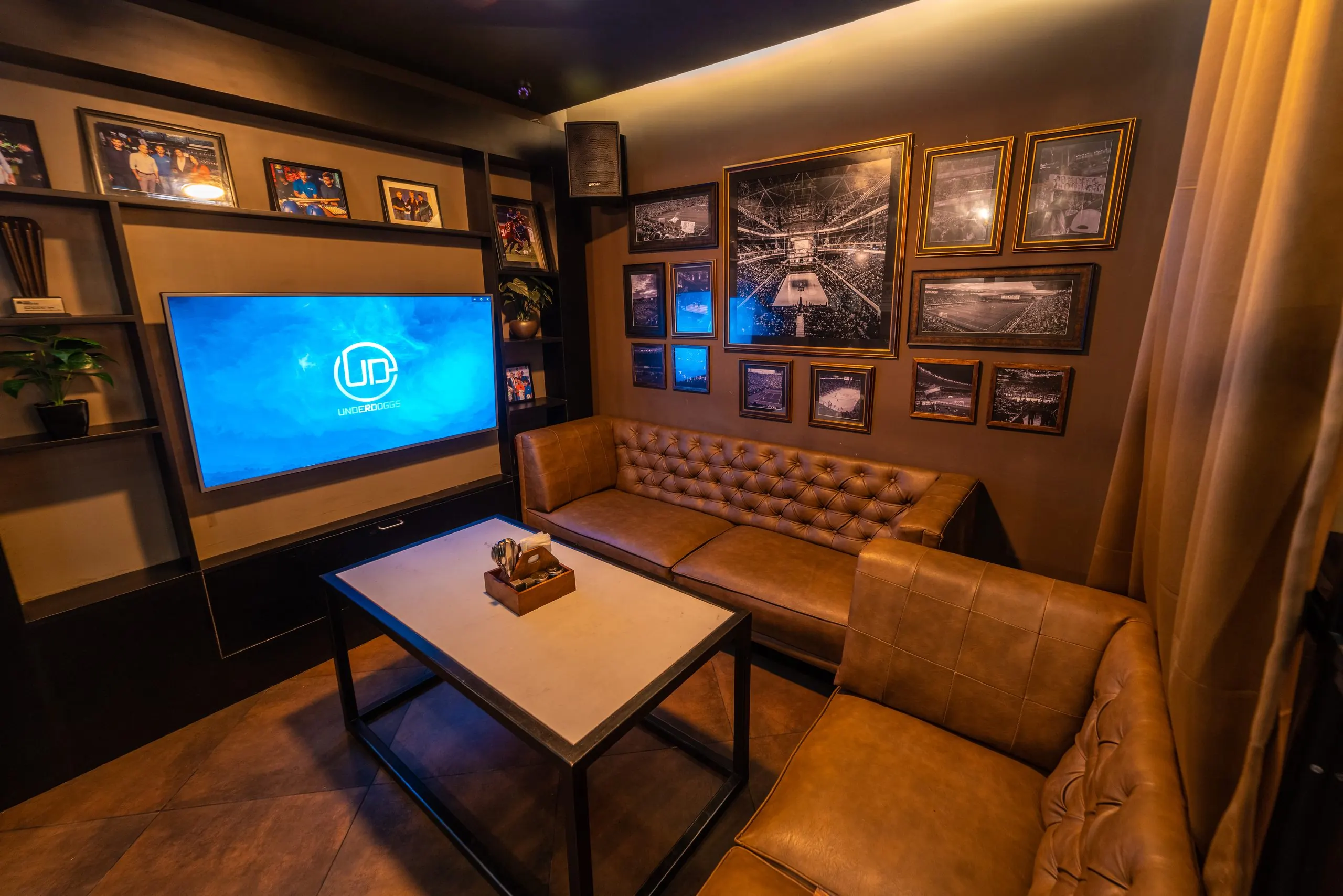 The private karaoke room at Underdoggs Aerocity, with leather seating and framed photographs