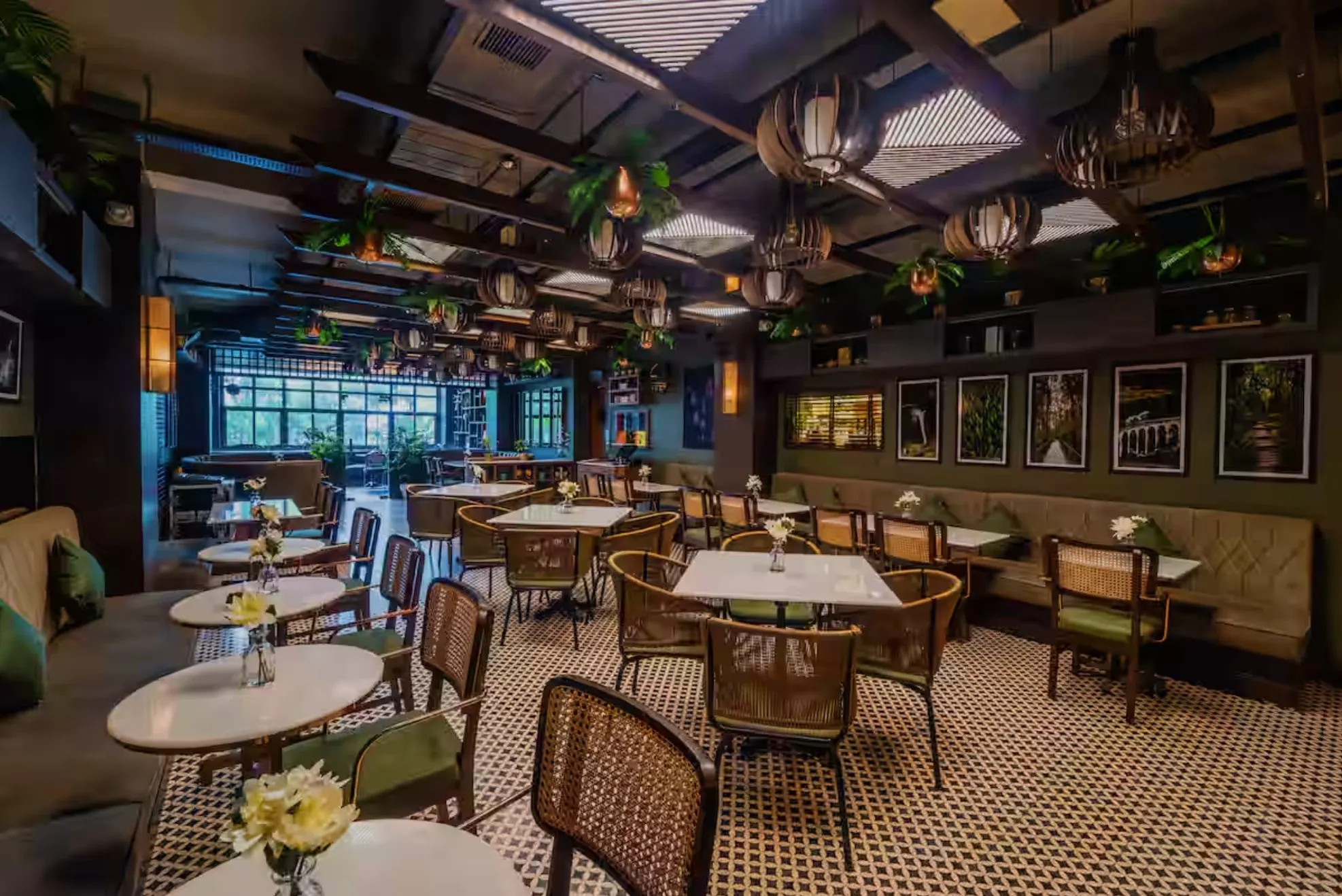 A wide view of Uptown Escape's dining room, round and square marble tables set beneath woven pendants